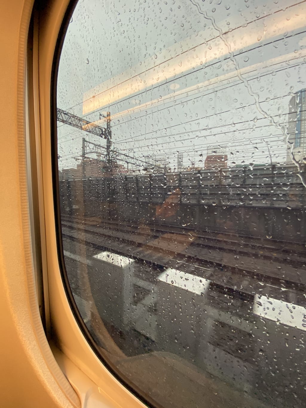 Window seat view inside shinkansen Nozomi, and rain outside